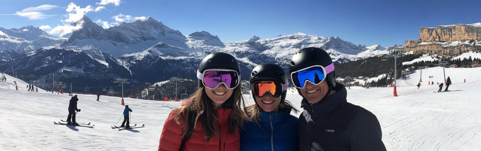 three friends enjoy a memorable skiing experience surrounded by breathtaking snowy mountains and vibrant blue skies. the atmosphere is lively and inviting